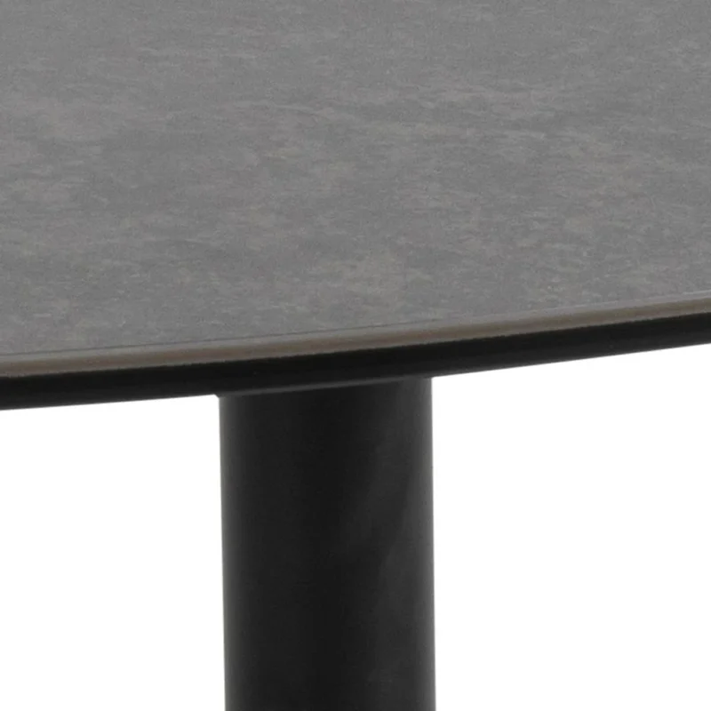 Close-up van de rand van Salontafel Zwart 95 x 41 CM Driehoek, een rond zwart kunststof tafelblad ondersteund door een enkele cilindrische zwart metalen poot tegen een effen achtergrond.