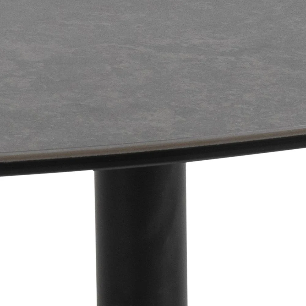 Close-up van de rand van Salontafel Zwart 95 x 41 CM Driehoek, een rond zwart kunststof tafelblad ondersteund door een enkele cilindrische zwart metalen poot tegen een effen achtergrond.