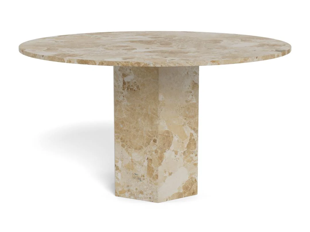 De Eettafel Naxos 130 CM Rond Marmer Massief heeft een dik, plat rond marmeren blad met een enkele brede rechthoekige voet en een natuurlijk beige en lichtbruin steenpatroon.