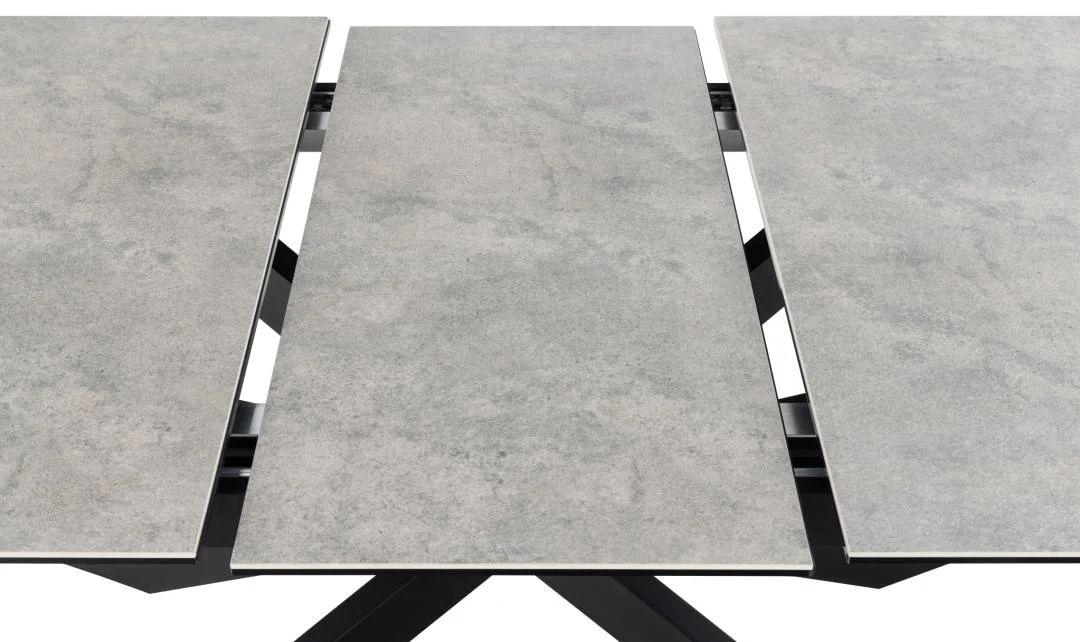 Een close-up van de Eettafel Irwine 90 x 76 CM Rechthoek, met een keramisch steenachtig blad met een centraal uittrekblad en een zwart stalen frame.