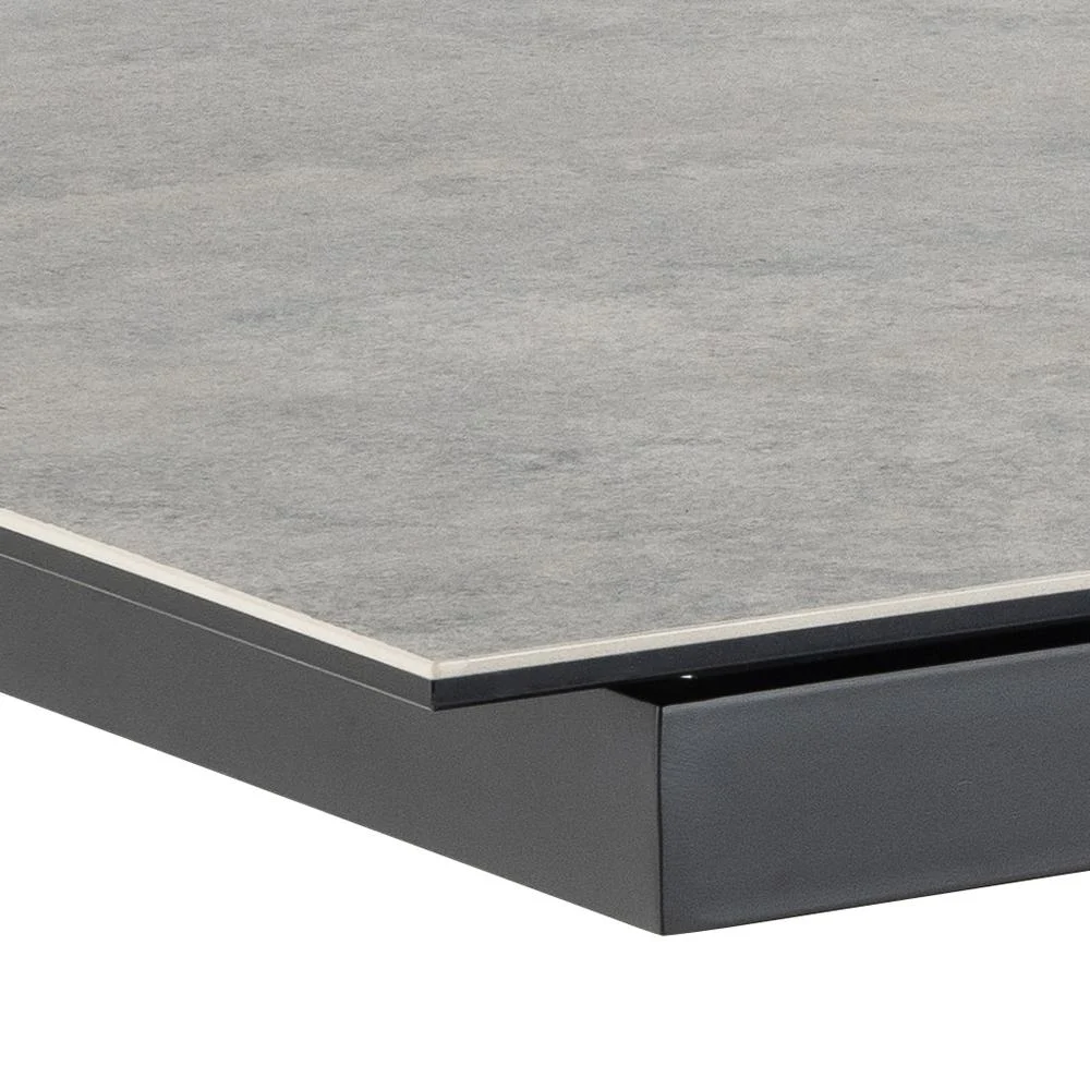 Een close-up van de Eettafel Irwine 90 x 76 CM Rechthoek toont het grijze keramische tafelblad met een slanke, lichte rand boven een donker, rechthoekig stalen onderstel.