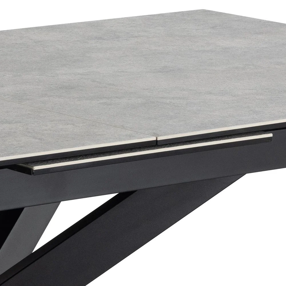 Close-up van de Eettafel Irwine (90 x 76 cm), met een lichtgrijs keramisch blad en een zwart hoekig stalen onderstel. Deze rechthoekige eettafel heeft strakke lijnen en een strak, eigentijds ontwerp.