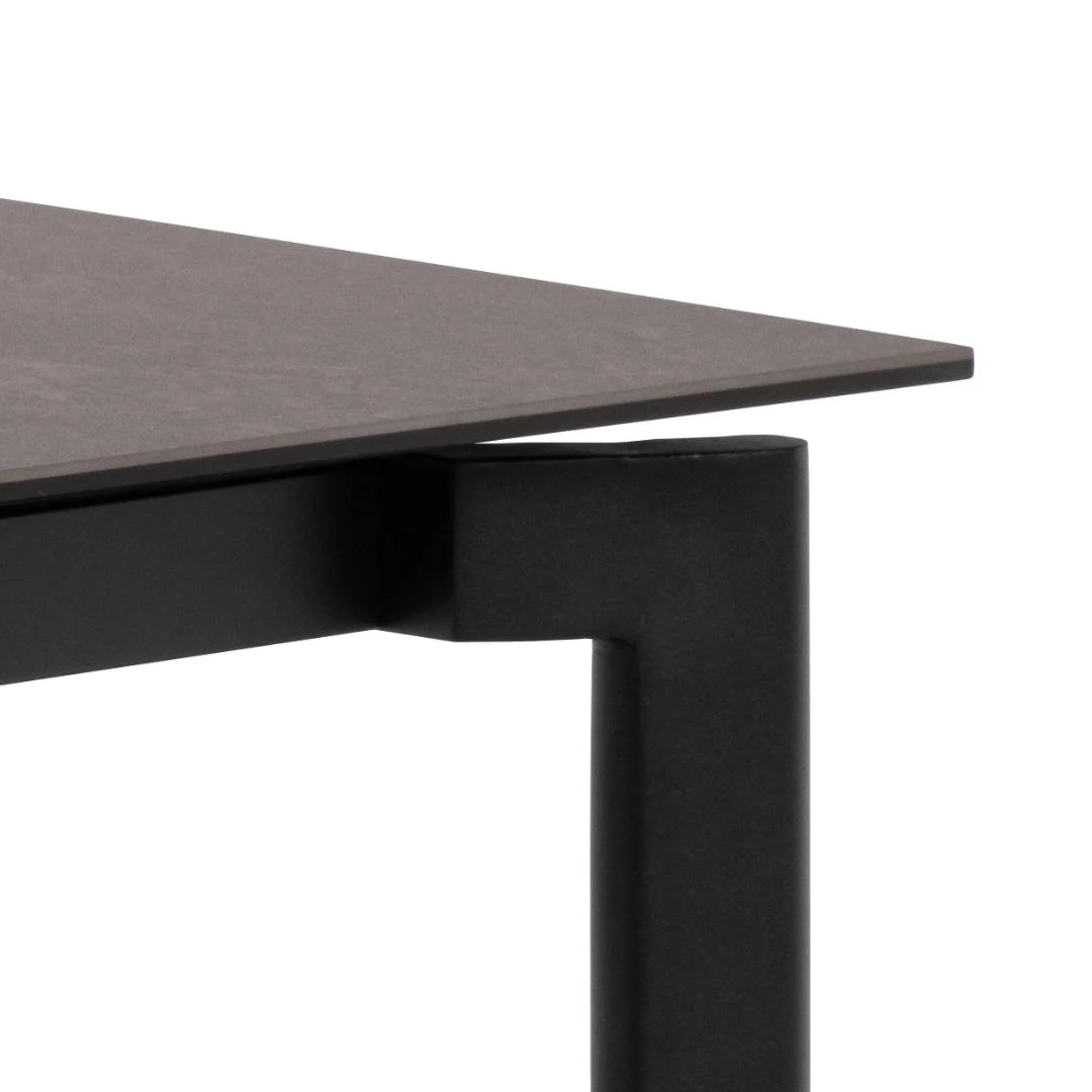 Close-up van Eettafel Palermo 90 x 76 CM Rechthoek, met een dun, donker keramiek robuust tafelblad en een stevige zwarte cilindrische metalen poot.