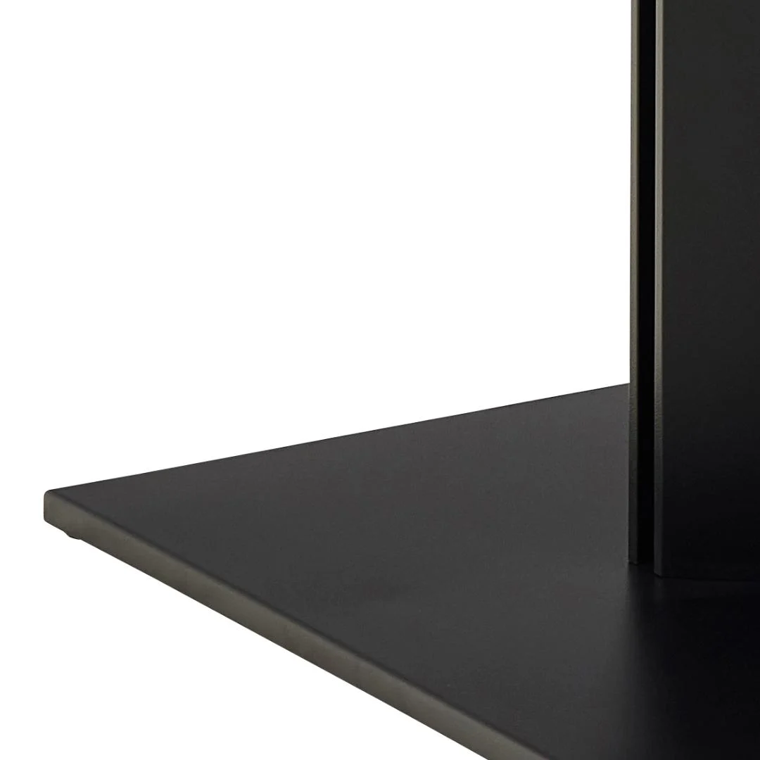 Close-up van de hoek van de Eettafel Nieuwe Sfeer 200 x 100 CM Rond, met een platte zwarte metalen voet met een verticaal zwart paneel, gemaakt van keramiek en metaal, tegen een effen achtergrond.