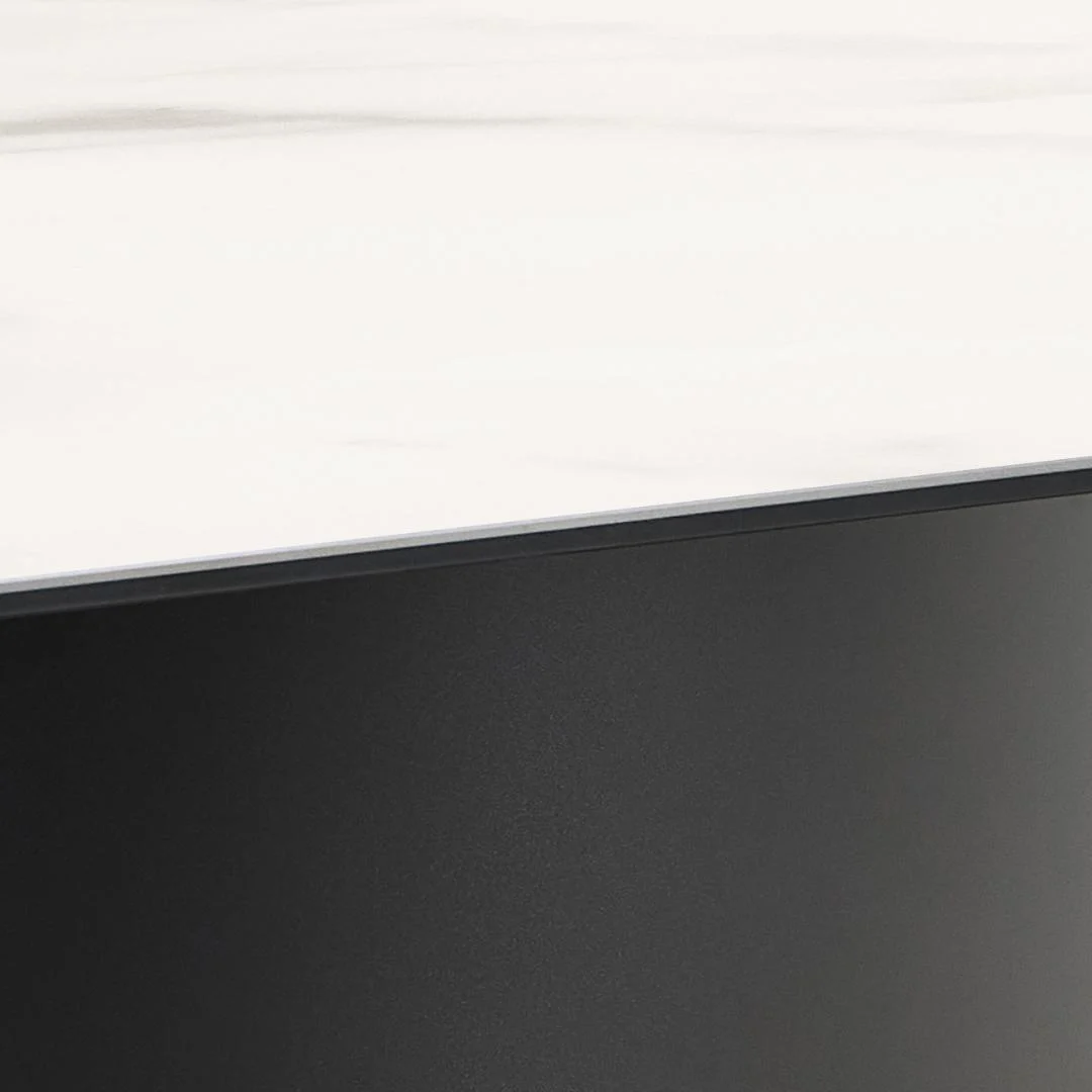 Close-up van de Eettafel Marbella 200 x 100 CM Rechthoek: een glad, wit keramiek tafelblad met subtiele grijze adering, op een massief zwart rechthoekig stalen onderstel.