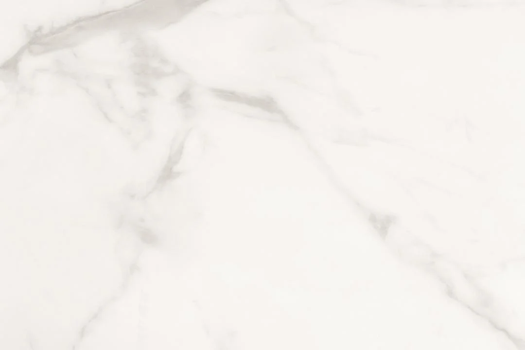 De Eettafel Marbella 200 x 100 CM Rechthoek heeft een keramisch stalen oppervlak met een witte marmer look, subtiele grijze aderen en natuurlijke diagonale patronen voor een gladde, elegante uitstraling.