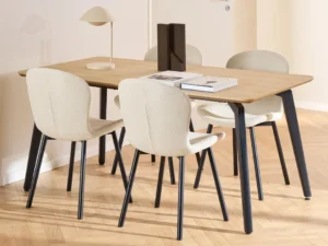 Een moderne eethoek met de Eettafel Cadiz 90 x 75 CM Rechthoek MDF staal, vier crèmekleurig gestoffeerde stoelen, een beige tafellamp, twee boeken, een decoratief object, alles op een lichte visgraat houten vloer.