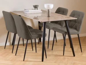 De Eettafel Wicklow 80 x 75 CM Rond Keramiek, gecombineerd met vier grijs gestoffeerde stoelen met zwarte poten, staat op een lichthouten vloer met daarop twee decoratieve schalen en een stapel boeken.