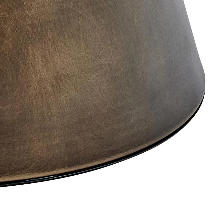 Een close-up van de Salontafel Brons, een 70 cm ronde stalen salontafel in bruin met een subtiel gevlekt, licht gestructureerd oppervlak en gladde, gebogen rand.