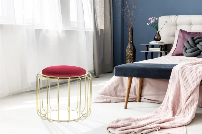 Een moderne slaapkamer met een getuft bed, grijs en roze beddengoed, bijzettafel met boeken en een vaas, en de Bijzettafel Goud, Rood Rond Glas bij grote ramen met transparante witte gordijnen.