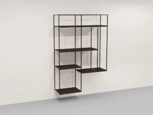 De Izola BOEKENREK HANG DO is een minimalistisch zwart metalen wandrek met een asymmetrisch geometrisch ontwerp met open rechthoekige en vierkante vakken, getoond geïnstalleerd op een witte muur boven een grijze vloer.