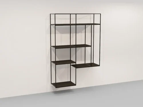 De Izola BOEKENREK HANG DO is een minimalistisch zwart metalen wandrek met een asymmetrisch geometrisch ontwerp met open rechthoekige en vierkante vakken, getoond geïnstalleerd op een witte muur boven een grijze vloer.