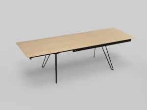 De Izola TAFEL 220-320 E02M is een rechthoekige houten tafel met een lichtgekleurd blad, een zwart metalen frame en dunne, schuine poten, tegen een effen lichtgrijze achtergrond.