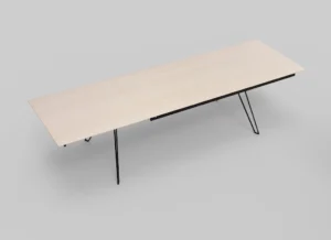 De Izola TAFEL 220-320 WWM is een minimalistische rechthoekige tafel met een licht houten blad en slanke zwarte metalen poten tegen een eenvoudige lichtgrijze achtergrond.