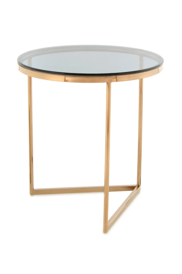 De Bijzettafel Grijs Staal Design is een moderne ronde bijzettafel met een helder glazen blad en een goud metalen frame met drie slanke poten die een driehoekige basis vormen.