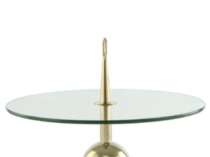 De Bijzettafel Transparant, Goud Staal is een moderne ronde glazen tafel met een centrale goudstalen steun met daarop een puntige punt en een ronde lus. Het metalen onderstel is gedeeltelijk zichtbaar.