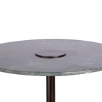 De Bijzettafel Groen Marmer heeft een rond groen marmeren tafelblad met een slank profiel, een klein rond metalen accent in het midden en wordt ondersteund door een enkele slanke metalen poot.