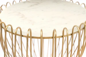 De Bijzettafel Messing, Wit Rond Marmer is een ronde tafel met een wit marmeren blad en een goudkleurig metalen onderstel ontworpen met lusvormige, gebogen stangen in een decoratief patroon.