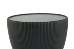 Een zwarte, ronde Bijzettafel Zwart Steen Design met geribbelde zijkanten en een glad, plat bovenvlak, afgebeeld tegen een witte achtergrond.