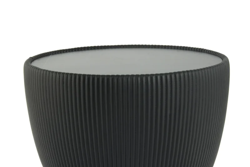 Een zwarte, ronde Bijzettafel Zwart Steen Design met geribbelde zijkanten en een glad, plat bovenvlak, afgebeeld tegen een witte achtergrond.