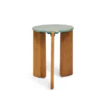 De bijzettafel Lila - Walnoot heeft een klein rond groen blad en drie stevige, verticale walnotenhouten poten die gelijkmatig verdeeld zijn rond de basis. Het moderne, minimalistische ontwerp steekt mooi af tegen een effen witte achtergrond.