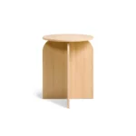 De Bijzettafel Felix - Naturel Ø45 is een kleine, ronde bijzettafel van licht hout met een minimalistisch ontwerp en kruisende vlakke panelen als basis.