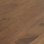 Een close-up van de Bella Eettafel Naturel - 180cm benadrukt de warmbruine houten afwerking, die de natuurlijke houtnerf en subtiele kleur- en textuurvariaties laat zien.