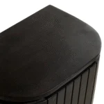 Close-up van de bovenste hoek van het Nachtkastje, met donkerbruin mangohout in een industriële stijl met een gestructureerd oppervlak en gladde, afgeronde rand.