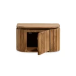Een klein, halfrond Nachtkastje Lichtbruin Mangohout met verticale lamellen en een industriële look, met een scharnierende deur die gedeeltelijk opengaat om een leeg interieur te onthullen.