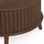 De Salontafel 65 CM Rond is een ronde, donkerbruine houten salontafel met verticale zijlatten en drie schuine poten tegen een witte achtergrond.