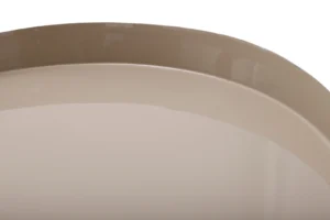 Close-up van de ronde, glanzende rand van de Bijzettafel Taupe Ijzer Compact, een beige ijzeren bijzettafel, tegen een witte achtergrond.