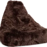 De Zitzak Schapenvacht Lang Wol Bruin is een zachte, bruine zitzak van imitatiebont met een driehoekige rugleuning en een pluche, gezellige textuur.