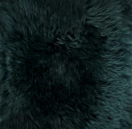 Een close-up van de Zitzak Schapenvacht Lang Wol Groen toont een dichte, zwarte en pluizige vacht met een zachte, licht golvende textuur en diepgroene accenten.