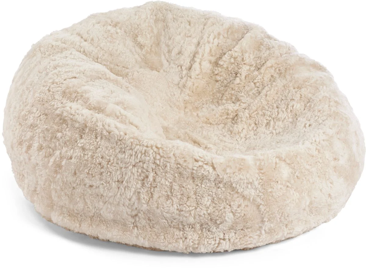 De Zitzak Schapenvacht Kort Wol Beige Medium is een rond, beige bed met pluche, korte wol ontworpen voor comfort en gezelligheid voor kleine katten of honden.