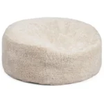De Zitzak Schapenvacht Rond Kort Wol Beige is een rond, pluche beige bed met zachte, donzige korte wol en een gezellige centrale onderdruk.