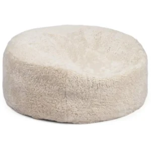 De Zitzak Schapenvacht Rond Kort Wol Beige is een rond, pluche beige bed met zachte, donzige korte wol en een gezellige centrale onderdruk.