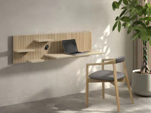 Lichte houten Napoli bureau E02M aan de muur met laptop, kleine plankjes en een bureaustoel. Zachte belichting, minimalistisch design.