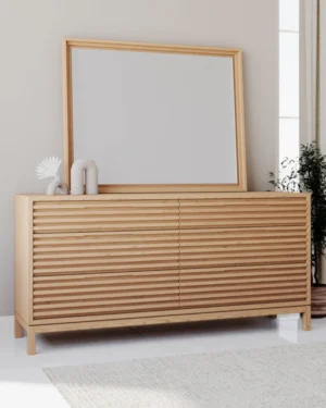 Het Nachtkastje 46 x 173 x 84 CM, een licht houten dressoir met horizontale latten, staat tegen een neutrale muur. Bovenop rust een grote spiegel met bijpassende lijst, naast minimalistisch decor en een potplant op de achtergrond.