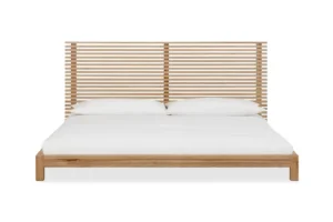 Vooraanzicht van een platformbed 160x200 cm van massief essenhout. Het bed heeft een lattenbodem hoofdeinde en wit beddengoed. Lichte tinten.