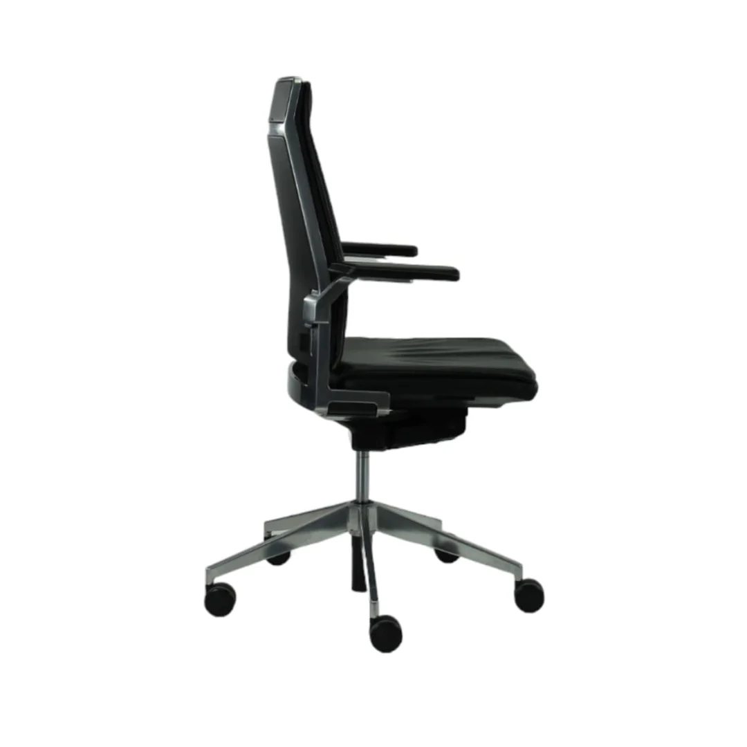 De Bureaustoel Gereviseerde Dynamobel Zwart Stof Refurbished is een moderne zwarte bureaustoel met armleuningen, een hoge rugleuning, een metalen onderstel met vijf wielen en verstelbare hoogte, afgebeeld in zijprofiel.
