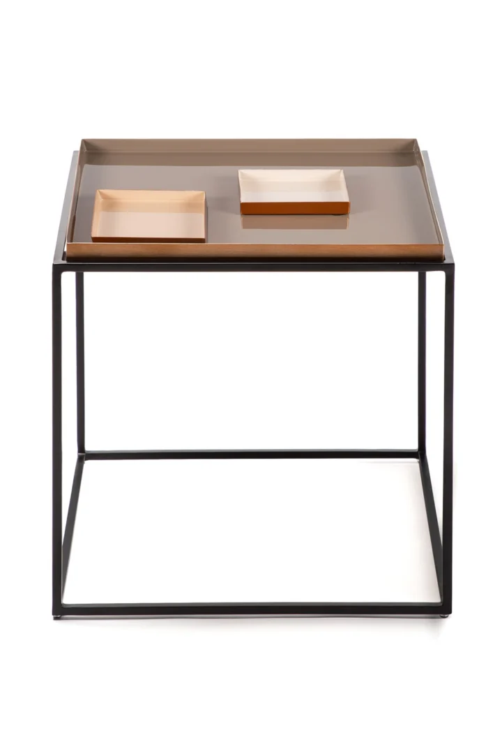 De Bijzettafel Crème Rond is een moderne ronde bijzettafel met een zwart metalen frame en een beige tafelblad. De tafel wordt getoond met twee rechthoekige beige dienbladen van verschillende afmetingen erop.