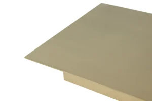 Een close-up van de hoek van de Bijzettafel Zwart, Roest Vierkant Marmer-een platte, rechthoekige tafel met een goudkleurig metalen blad tegen een witte achtergrond.