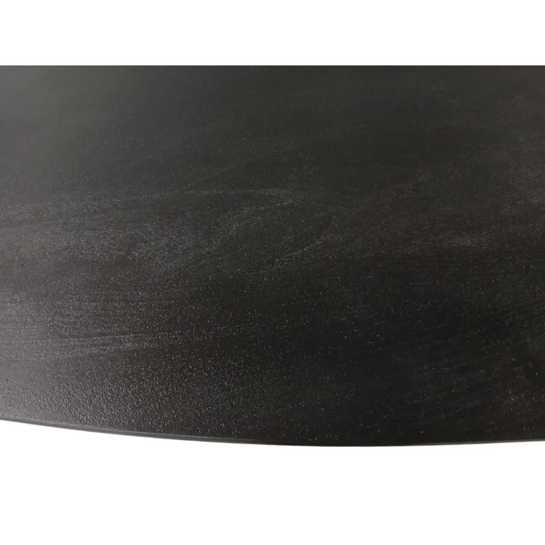 Close-up van de Eettafel Brandy Zwart, een ovale tafel van 180 cm, met het gladde donkerzwarte houten oppervlak met subtiele nerfstructuur tegen een witte achtergrond.