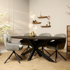 Een moderne eetkamer met de Eettafel Brandy Zwart 210 cm ovale tafel en vier grijze draaistoelen met zwart metalen poten. Een lichthouten vloer, beige muren en kleine decorplanken met een bloesemtak creëren een gezellige, elegante sfeer.