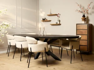Een moderne eetkamer met de 240 cm Eettafel Brandy Zwart ovale tafel, acht crème gestoffeerde stoelen, licht houten vloeren, een hoge houten kast, wandplanken met decor en bloementakken in een vaas.