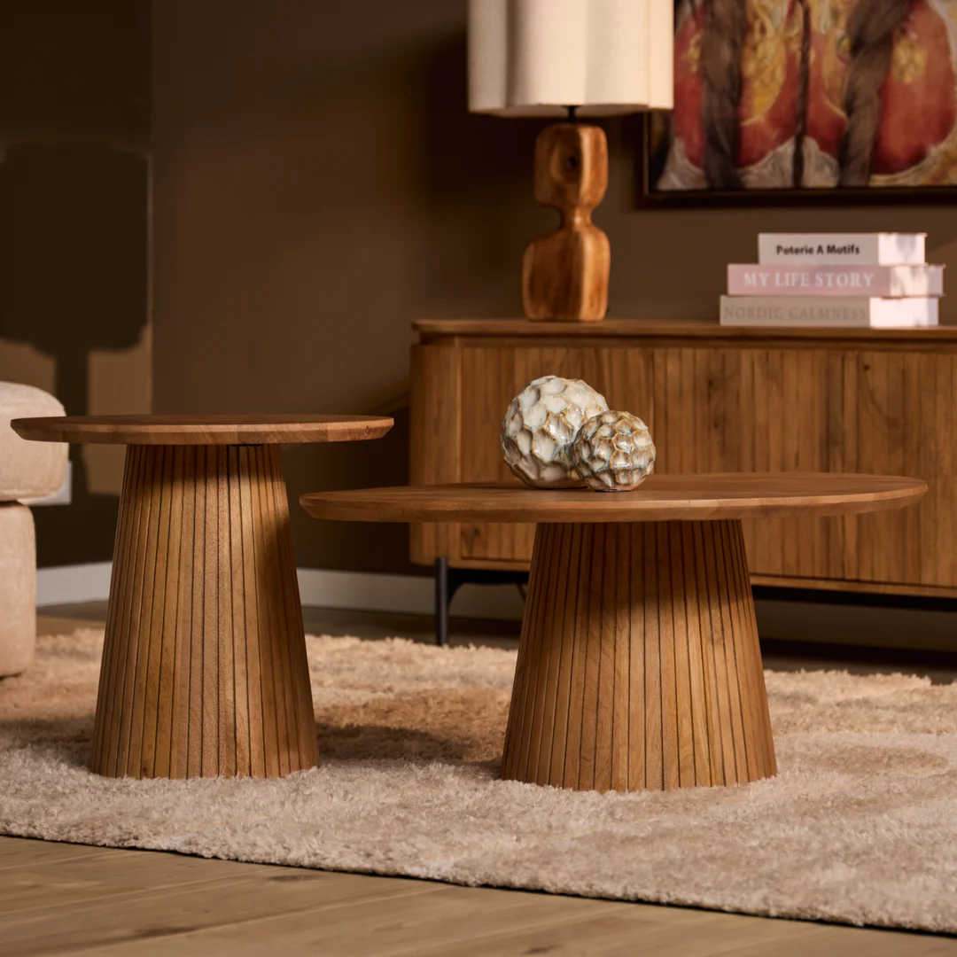 Houten salontafel design met ronde bladen en kegelvormige poten van latten. Warme kleuren, zacht licht, decoratieve objecten.