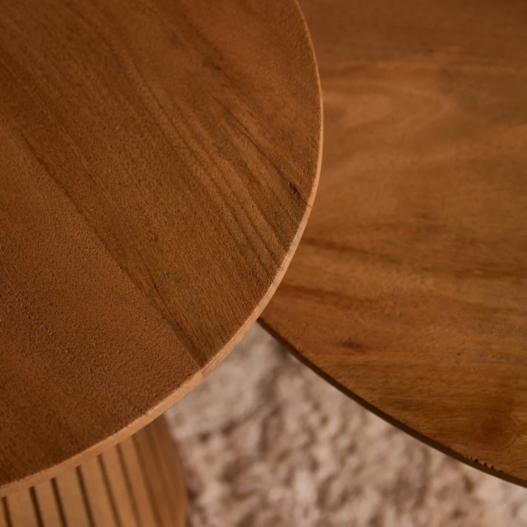 Houten salontafel Roest in close-up, ronde vorm. Warm licht accentueert het houtnerf detail. Zachte achtergrond geeft een huiselijke sfeer.