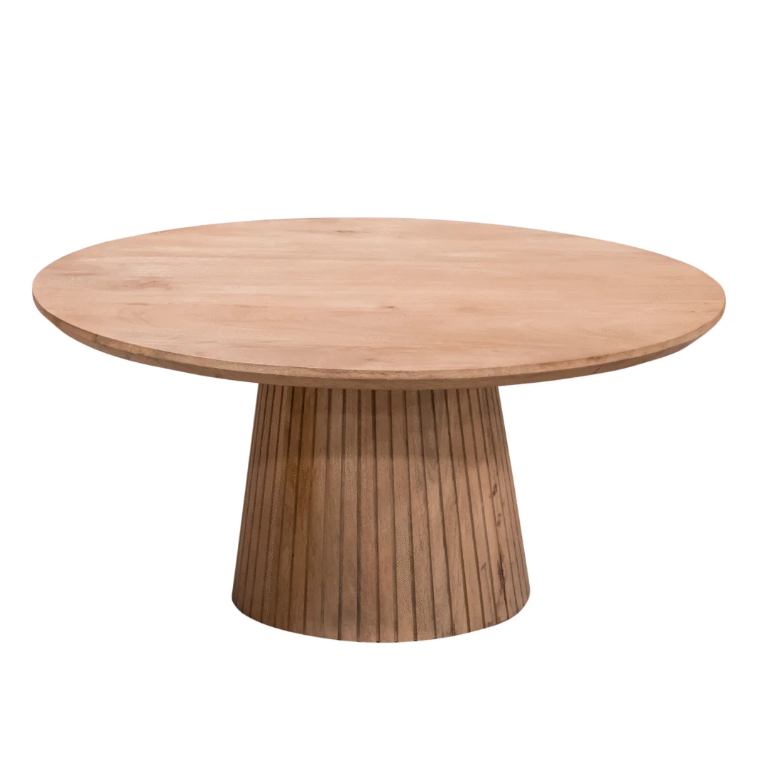 Vrijstaande ronde salontafel van lichtgekleurd hout, met een cilindervormige voet met verticale latten. Neutrale achtergrond.