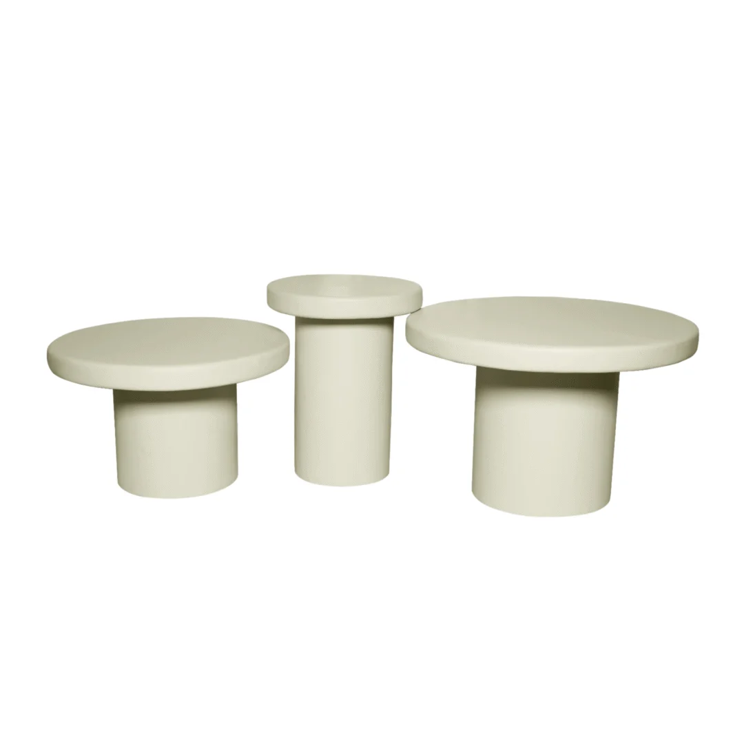 Drie zandkleurige salontafels van verschillende hoogtes, met cilindervormige poten, op een witte achtergrond. Minimalistisch design.