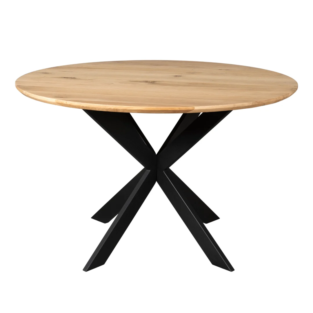 De Eiken eettafel Ferris | Rond 130 cm | Naturel is een ronde houten tafel met een licht houten blad en een modern zwart metalen onderstel met vier schuine poten die in het midden samenkomen.